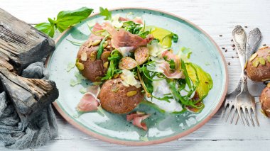 Proshutto, yumurta ve arugula ile sandviç. Kahvaltı. Tabakta. Üst te. Düz döşeme kompozisyonU Ücretsiz kopyalama alanı.