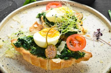 Ispanaklı sandviç, yumurta ve domates. Kruva -san. Kahvaltı. Tabakta. Üst te. Düz döşeme kompozisyonU Ücretsiz kopyalama alanı.