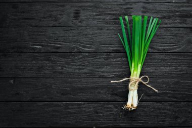 Ahşap arka plan üzerinde taze yeşil soğan. Üstten Görünüm. Metniniz için boş alan.