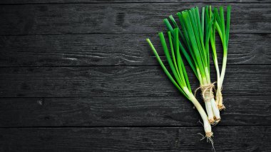 Ahşap arka plan üzerinde taze yeşil soğan. Üstten Görünüm. Metniniz için boş alan.
