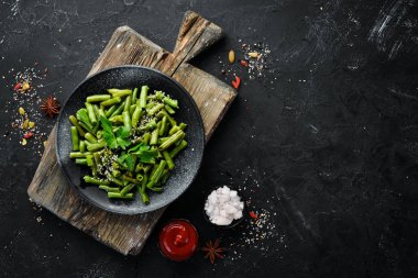 Haşlanmış Yeşil Kuşkonmaz Fasulyesi. Siyah bir tabakta. Üst te. Ücretsiz kopyalama alanı.