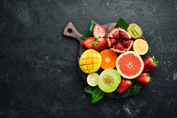 Frutas Tropicales Frescas Sobre Fondo Negro Cítricos Melones Granadas Fresas —  Fotos de Stock