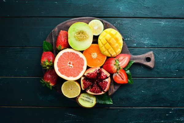 Frutas Tropicales Frescas Sobre Fondo Negro Cítricos Melones Granadas Fresas —  Fotos de Stock