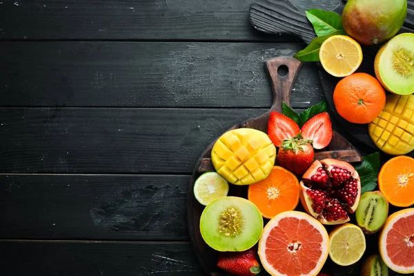 Frutas Tropicales Frescas Sobre Fondo Negro Cítricos Melones Granadas Fresas —  Fotos de Stock