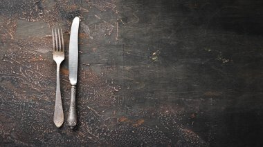 Karanlık bir arka plan üzerinde eski çatal bıçak takımı. Üst te. Ücretsiz kopyalama alanı.