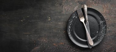 Karanlık bir arka plan üzerinde eski çatal bıçak takımı. Üst te. Ücretsiz kopyalama alanı.