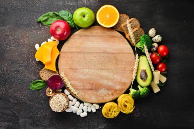 Doğal karbonhidratlı gıdalar: ekmek, makarna, avokado, un, kabak, brokoli, fasulye, ıspanak. Kahverengi bir arka plan üzerinde. Üst te. Ücretsiz kopyalama alanı.