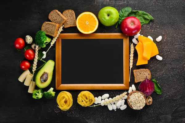 Doğal karbonhidratlı gıdalar: ekmek, makarna, avokado, un, kabak, brokoli, fasulye, ıspanak. Kahverengi bir arka plan üzerinde. Üst te. Ücretsiz kopyalama alanı.