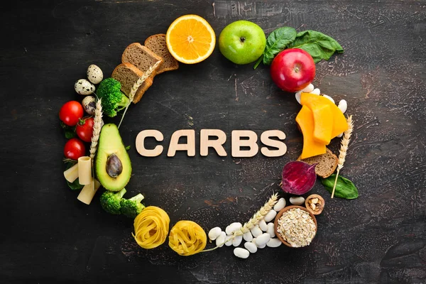 Foods with natural carbohydrates: bread, pasta, avocado, flour, pumpkin, broccoli, beans, spinach. On a brown background. Top view. Free copy space.