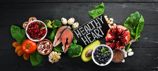 Food for heart health: Fish, blueberries, nuts, pomegranate, avocados, tomatoes, spinach, flax. The concept of healthy eating.