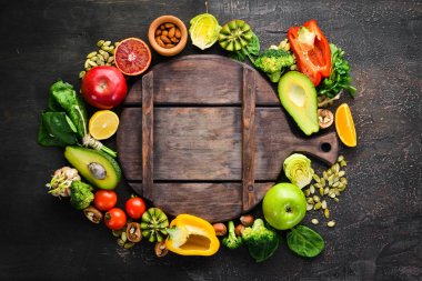 Sağlıklı vejetaryen gıda: avokado, ıspanak, elma, kırmızı biber, maydanoz, portakal, fındık, domates, sarımsak. Metniniz için en iyi görünüm boş alanı.