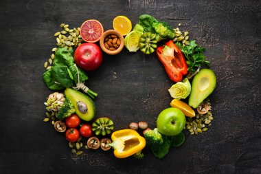 Sağlıklı vejetaryen gıda: avokado, ıspanak, elma, kırmızı biber, maydanoz, portakal, fındık, domates, sarımsak. Metniniz için en iyi görünüm boş alanı.