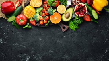 Taze meyveler, sebzeler ve meyveler. Siyah bir arka plan üzerinde. Banner Üstgörünüm. Metniniz için boş alan.