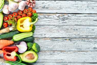 Taze sebzeler. Avokado, salatalık, soğan, sarımsak, domates, havuç, yabanturpu. Üst te. Metniniz için boş alan.