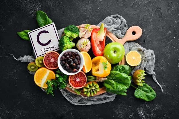含有维生素C的水果和蔬菜 花椰菜 奇异果 顶部视图 在黑色的石头背景上 — 图库照片