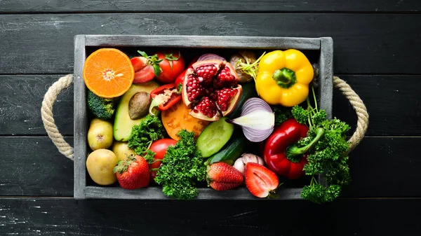 Fresh fruits, vegetables and berries. On a black background. Banner Top view. Free space for your text.