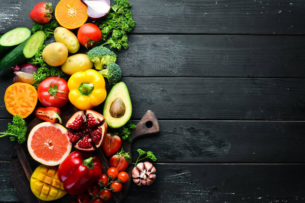 Fresh fruits, vegetables and berries. On a black background. Banner Top view. Free space for your text.