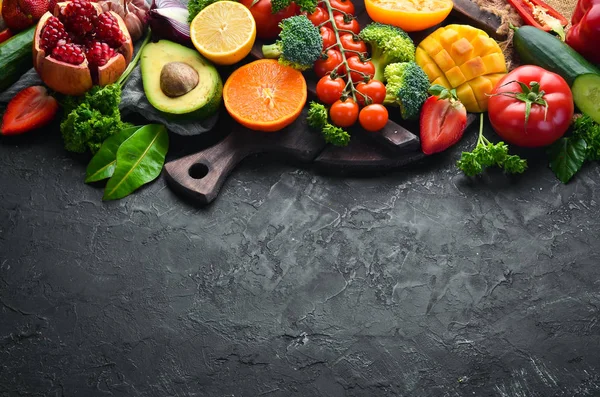 Fresh fruits, vegetables and berries. On a black background. Banner Top view. Free space for your text.