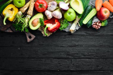 Taze sebzeler. Avokado, salatalık, soğan, sarımsak, domates, havuç, yabanturpu. Üst te. Metniniz için boş alan.