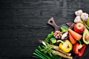 Taze sebzeler. Avokado, salatalık, soğan, sarımsak, domates, havuç, yabanturpu. Üst te. Metniniz için boş alan.