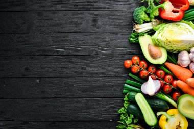 Taze sebzeler. Avokado, salatalık, soğan, sarımsak, domates, havuç, yabanturpu. Üst te. Metniniz için boş alan.