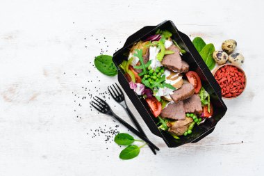 Patates, sebze ve yeşil bezelye ile dana eti. Teslimatla birlikte yemek. Üst te. Metniniz için boş alan. Rustik stil.