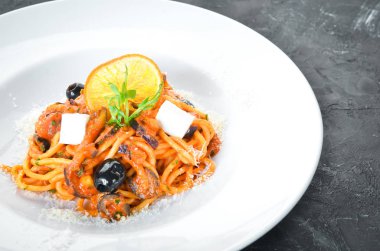 Bir tabakta domates, zeytin ve beyaz peynir ile spagetti. Üst te. Metniniz için boş alan.