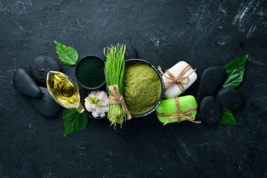 Zen taşları ve yaprakları ile su damlaları. Karanlık bir arka planda spa aksesuarları olan bir kaplıca. Üst Manzara. Metnin için boş yer.