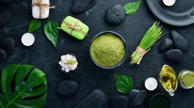 Zen taşları ve yaprakları ile su damlaları. Karanlık bir arka planda spa aksesuarları olan bir kaplıca. Üst Manzara. Metnin için boş yer.