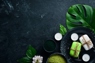 Zen taşları ve yaprakları ile su damlaları. Karanlık bir arka planda spa aksesuarları olan bir kaplıca. Üst Manzara. Metnin için boş yer.