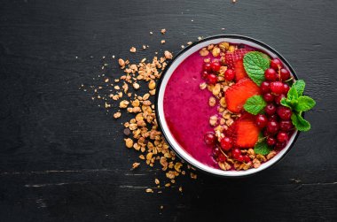 Granola, çilek, kırmızı kuş üzümü ve nane ile Smoothie kase. Kahvaltı. Üst te. Metniniz için boş alan.