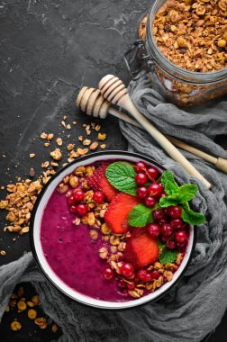 Granola, çilek, kırmızı kuş üzümü ve nane ile Smoothie kase. Kahvaltı. Üst te. Metniniz için boş alan.