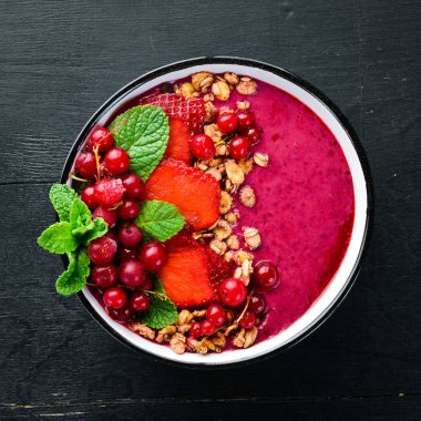 Granola, çilek, kırmızı kuş üzümü ve nane ile Smoothie kase. Kahvaltı. Üst te. Metniniz için boş alan.