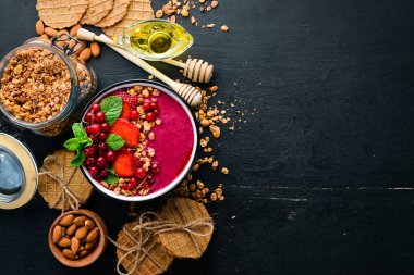 Granola, çilek, kırmızı kuş üzümü ve nane ile Smoothie kase. Kahvaltı. Üst te. Metniniz için boş alan.