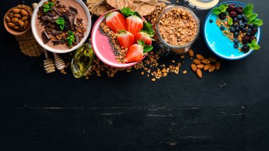 Yoğurt, taze meyve ve çilek ile renkli meyve smoothies büyük bir set. Sağlıklı bir kahvaltı. Üst te. Metniniz için boş alan. Siyah arka planda.