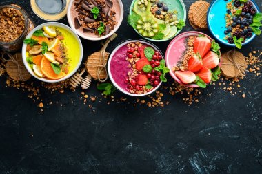 Yoğurt, taze meyve ve çilek ile renkli meyve smoothies büyük bir set. Sağlıklı bir kahvaltı. Üst te. Metniniz için boş alan. Siyah arka planda.
