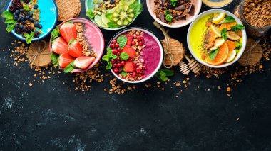 Yoğurt, taze meyve ve çilek ile renkli meyve smoothies büyük bir set. Sağlıklı bir kahvaltı. Üst te. Metniniz için boş alan. Siyah arka planda.