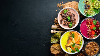 Yoğurt, taze meyve ve çilek ile renkli meyve smoothies büyük bir set. Sağlıklı bir kahvaltı. Üst te. Metniniz için boş alan. Siyah arka planda.