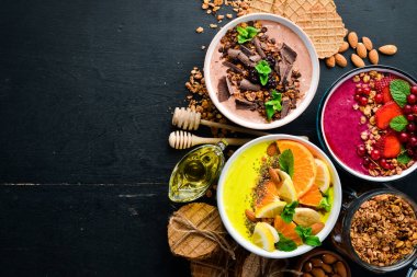 Yoğurt, taze meyve ve çilek ile renkli meyve smoothies büyük bir set. Sağlıklı bir kahvaltı. Üst te. Metniniz için boş alan. Siyah arka planda.