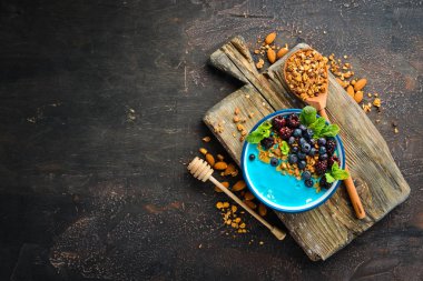 Mavi Spirulina ve Taze Meyve Smoothie Bowl böğürtlen, yaban mersini, granola ve yoğurt ile tepesinde. Kahvaltı. Üst te. Metniniz için boş alan.