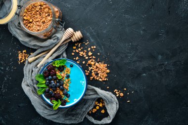Mavi Spirulina ve Taze Meyve Smoothie Bowl böğürtlen, yaban mersini, granola ve yoğurt ile tepesinde. Kahvaltı. Üst te. Metniniz için boş alan.