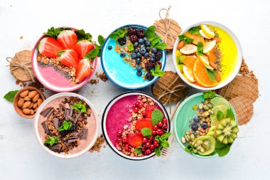 Sağlıklı bir kahvaltı. Yoğurt, taze meyve ve çilek ile renkli meyve smoothies. Üst te. Metniniz için boş alan. Beyaz arka planda.