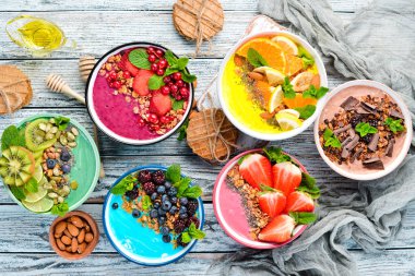 Sağlıklı bir kahvaltı. Yoğurt, taze meyve ve çilek ile renkli meyve smoothies. Üst te. Metniniz için boş alan. Beyaz arka planda.