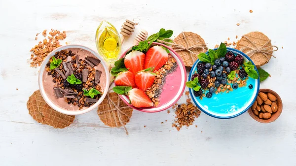 Sağlıklı bir kahvaltı. Yoğurt, taze meyve ve çilek ile renkli meyve smoothies. Üst te. Metniniz için boş alan. Beyaz arka planda.
