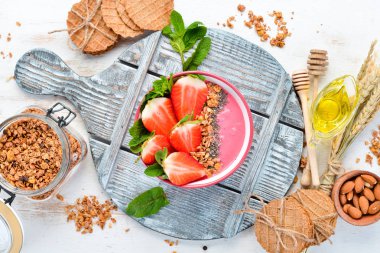 Taze çilek, granola, yoğurt ve chia tohumu ile Smoothie kase. Kahvaltı. Üst te. Metniniz için boş alan.