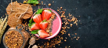 Taze çilek, granola, yoğurt ve chia tohumu ile Smoothie kase. Kahvaltı. Üst te. Metniniz için boş alan.