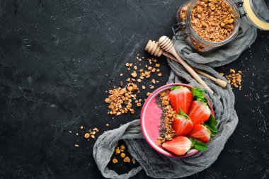 Taze çilek, granola, yoğurt ve chia tohumu ile Smoothie kase. Kahvaltı. Üst te. Metniniz için boş alan.