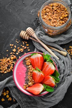 Taze çilek, granola, yoğurt ve chia tohumu ile Smoothie kase. Kahvaltı. Üst te. Metniniz için boş alan.