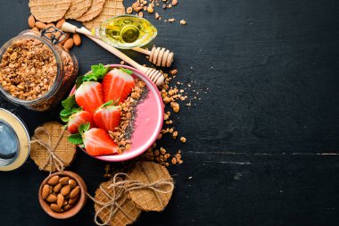 Taze çilek, granola, yoğurt ve chia tohumu ile Smoothie kase. Kahvaltı. Üst te. Metniniz için boş alan.