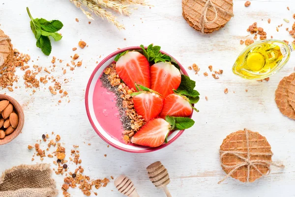Taze çilek, granola, yoğurt ve chia tohumu ile Smoothie kase. Kahvaltı. Üst te. Metniniz için boş alan.